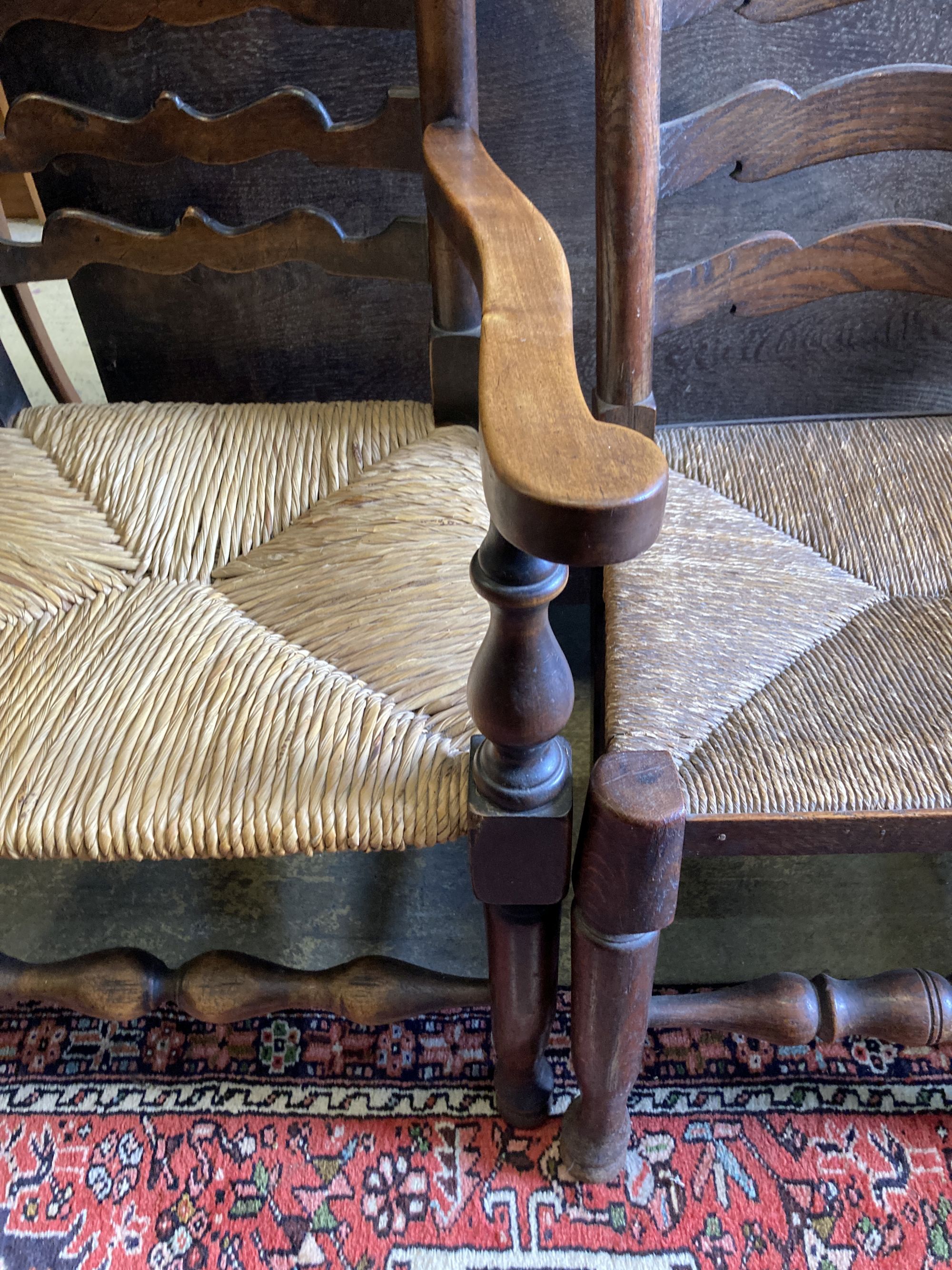 A harlequin set of seven oak and beech rush seated, ladder back dining chairs